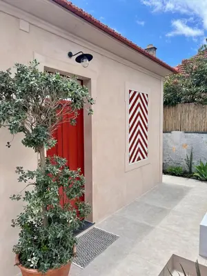 a red door on a house with a plant at THE BOAT HOUSE Sea Front and Private Pool in Funchal