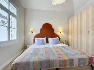 a bedroom with a large bed with a striped blanket at THE BOAT HOUSE Sea Front and Private Pool in Funchal