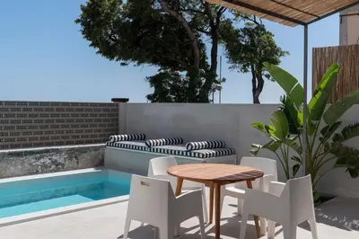a patio with a table and chairs next to a pool at THE BOAT HOUSE Sea Front and Private Pool in Funchal