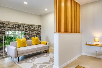 a living room with a couch and yellow pillows at Ricardo House, a Home in Madeira in Calheta