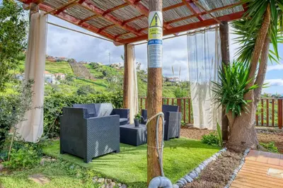 a patio with chairs and a pergola at Ricardo House, a Home in Madeira in Calheta