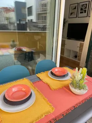 a table with two plates on a red and yellow table cloth at Modern City Apartment Funchal in Funchal