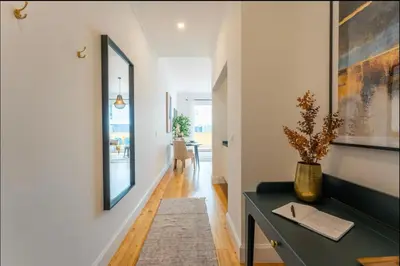 a living room with a desk and a hallway at Modern City Apartment Funchal in Funchal