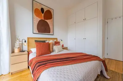 a bedroom with a large bed with orange pillows at Modern City Apartment Funchal in Funchal