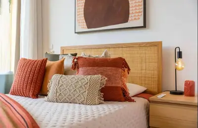 a bed with a bunch of pillows on it at Modern City Apartment Funchal in Funchal
