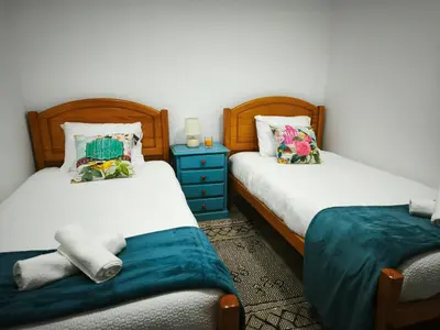 a bedroom with two beds and a blue dresser at Apartamento MONTECORUJEIRA in Funchal