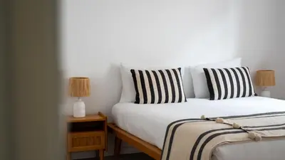 a white bed with black and white pillows on it at Amaro Oasis by LovelyStay in Funchal