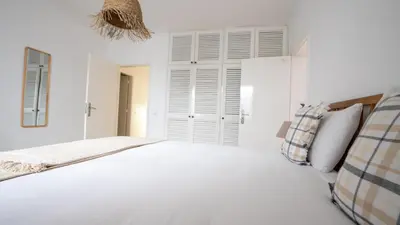 a white bedroom with a bed and white shutters at Amaro Oasis by LovelyStay in Funchal