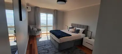 a bedroom with a bed with a view of the ocean at Radiantescapadela in Estreito da Calheta