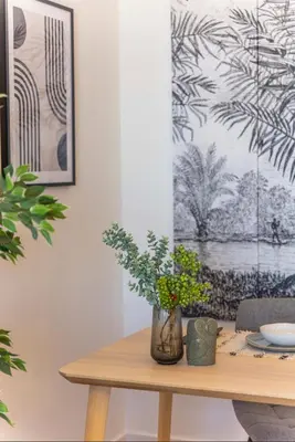 a dining room table with a vase of flowers on it at Island Time Studio with Sea View in Funchal