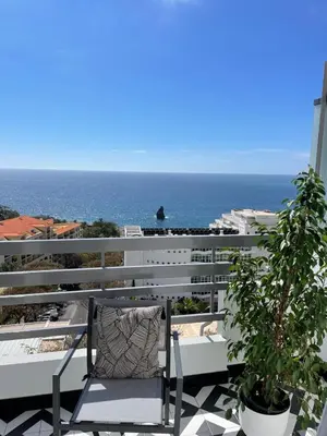a chair on a balcony with the ocean in the background at Island Time Studio with Sea View in Funchal