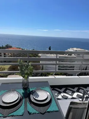 a table with two hats on top of a balcony at Island Time Studio with Sea View in Funchal
