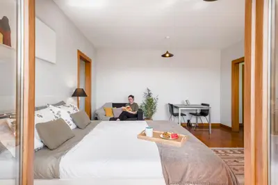 a man sitting on a bed in a room at Funchal Heritage Studio in Funchal