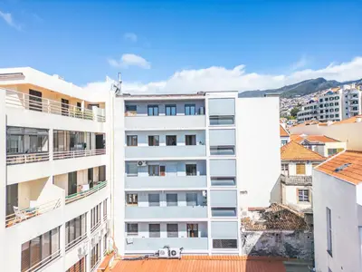 a white apartment building with balconies and buildings at Funchal Heritage Studio in Funchal