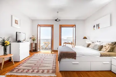 a white bedroom with a bed and a tv at Funchal Heritage Studio in Funchal