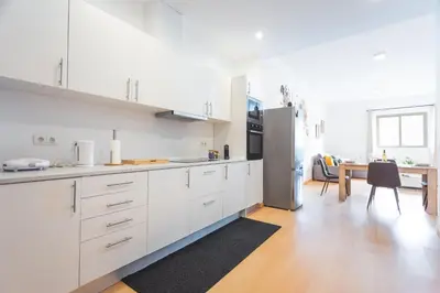 a kitchen with white cabinets and a dining table at Sao Pedro Central Flat by Atlantic Holiday in Funchal