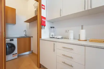 a kitchen with white cabinets and a washer and dryer at Sao Pedro Central Flat by Atlantic Holiday in Funchal