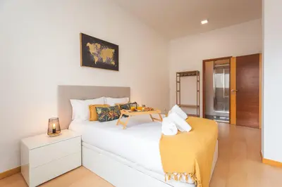 a bedroom with a bed with a table on it at Sao Pedro Central Flat by Atlantic Holiday in Funchal