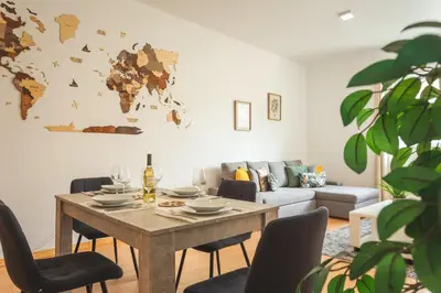 a living room with a table and a world map on the wall at Sao Pedro Central Flat by Atlantic Holiday in Funchal