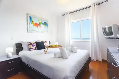 a white room with a bed and a tv at Sweet Home Reis Magos by Atlantic Holiday in Caniço