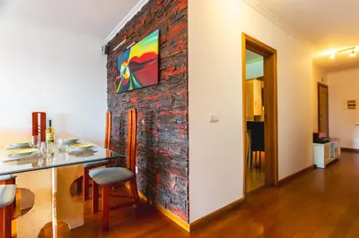 a room with a brick wall with a painting on it at Sweet Home Reis Magos by Atlantic Holiday in Caniço
