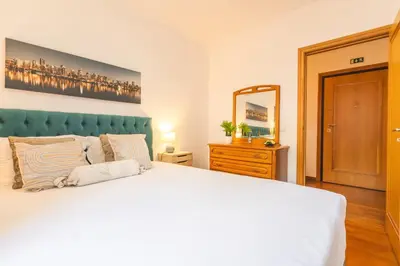 a bedroom with a large white bed and a mirror at Sweet Home Reis Magos by Atlantic Holiday in Caniço