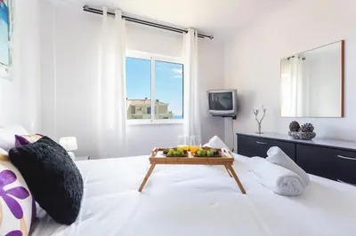 a white bedroom with a tray of fruit on a bed at Sweet Home Reis Magos by Atlantic Holiday in Caniço