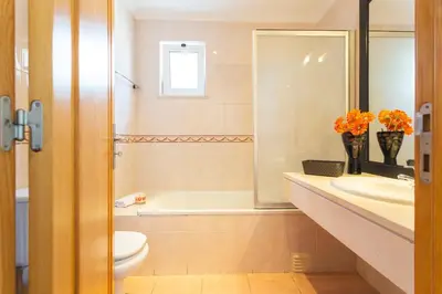 a bathroom with a toilet and a sink and a tub at Sweet Home Reis Magos by Atlantic Holiday in Caniço