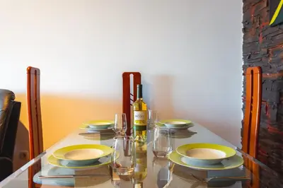 a table with plates and glasses and a bottle of wine at Sweet Home Reis Magos by Atlantic Holiday in Caniço