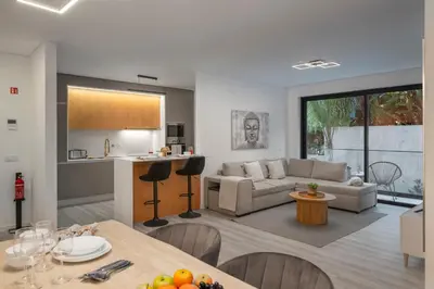 a kitchen and living room with a couch and a table at Uptown II by An Island Apart in Funchal
