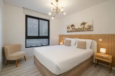a bedroom with a large white bed and a chair at Uptown II by An Island Apart in Funchal