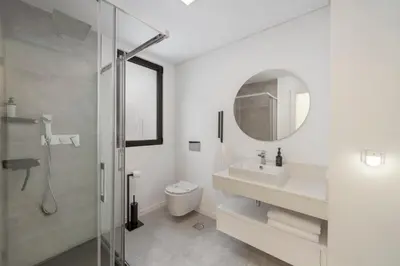 a bathroom with a toilet and a sink and a mirror at Uptown II by An Island Apart in Funchal