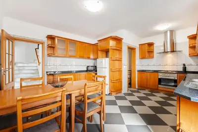 a kitchen with wooden cabinets and a checkered floor at SunRise Vila in Estreito da Calheta