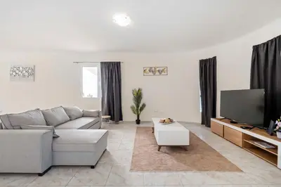 a living room with a couch and a tv at SunRise Vila in Estreito da Calheta