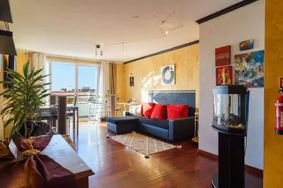 a living room with a blue couch and red pillows at GuestReady - A homely retreat in São Martinho in Funchal
