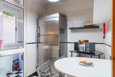a kitchen with a table and a refrigerator at GuestReady - A homely retreat in São Martinho in Funchal