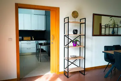 a room with a kitchen with a table and a door at Quinta das Rosas in Ribeira Brava