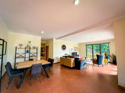 a living room with a wooden table and chairs at Quinta das Rosas in Ribeira Brava