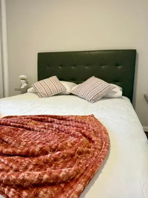 a bed with a blanket and two pillows on it at Funchal Center Inn in Funchal