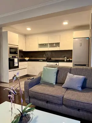 a living room with a couch and a kitchen at Funchal Center Inn in Funchal