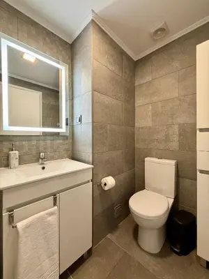 a bathroom with a toilet and a sink and a mirror at Funchal Center Inn in Funchal