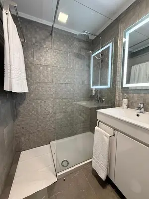 a bathroom with a shower and a tub and a sink at Funchal Center Inn in Funchal