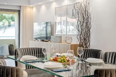 a dining room with a stone wall and a table and chairs at White House Premium in Funchal