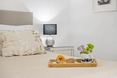 a white bedroom with a bed and a chair at White House Premium in Funchal