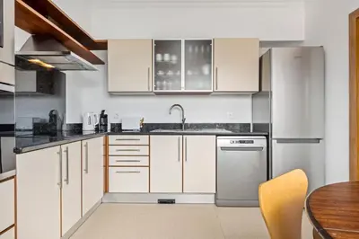 a kitchen with white cabinets and black counter tops at White House Premium in Funchal
