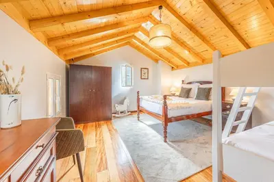 a bedroom with a bed and a wooden ceiling at Recanto do Pomar - Three bedroom villa in Ponta do Sol