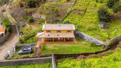 a house with a car parked in front of it at Recanto do Pomar - Three bedroom villa in Ponta do Sol