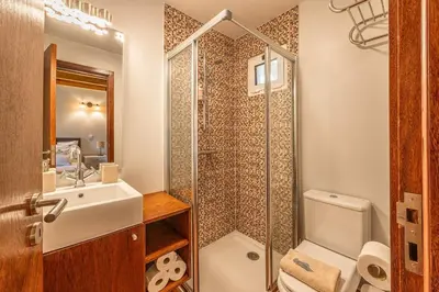 a bathroom with a shower and a toilet and a sink at Recanto do Pomar - Three bedroom villa in Ponta do Sol