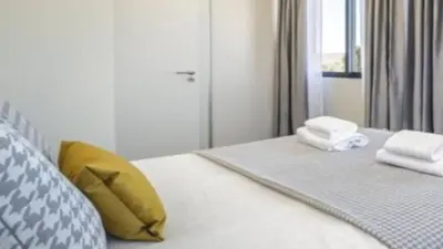a bed with a yellow pillow and towels on it at Apartment superb in Funchal in Funchal