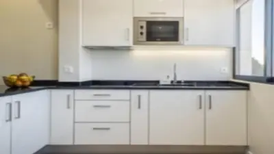 a white kitchen with a sink and a microwave at Apartment superb in Funchal in Funchal